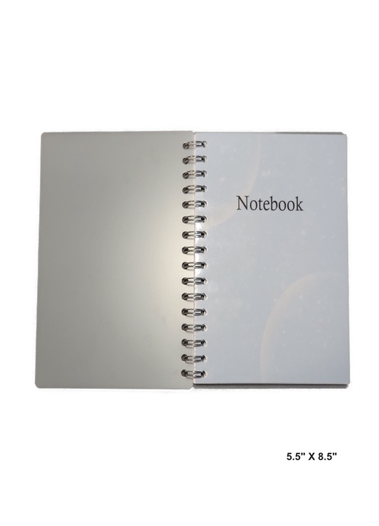 Image of hand-made 5.5" x 8.5" notebook with two moons in each conner making it feel out of space. The notebook's pages are lined for writing or journaling.